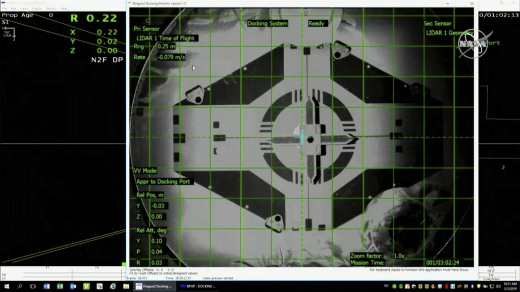 In this image taken from NASA Television, Sunday, March 3, 2019, a live screen shows docking scene of SpaceX's new crew capsule and the International Space Station Sunday, March 3, 2019. SpaceX's ...