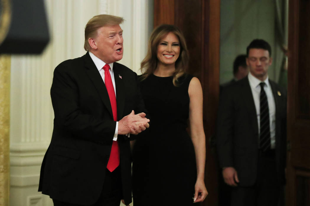 President Donald Trump with first lady Melania Trump, greets invited guests during a National African American History Month reception in the East Room of the White House in Washington, Thursday, ...