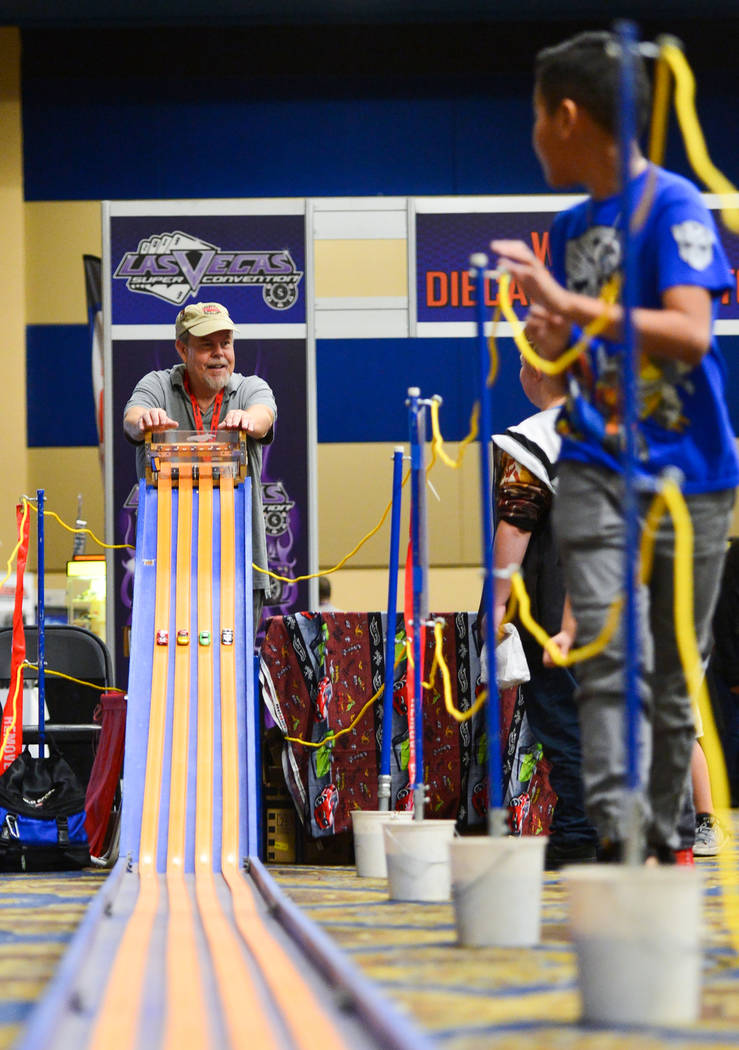 Kids run alongside the downhill Hot Wheels track as Matt Marion, left, opens the gate to start a race at Las Vegas Toy and Comic Convention at the Westgate Resort and Casino in Las Vegas, on Sunda ...