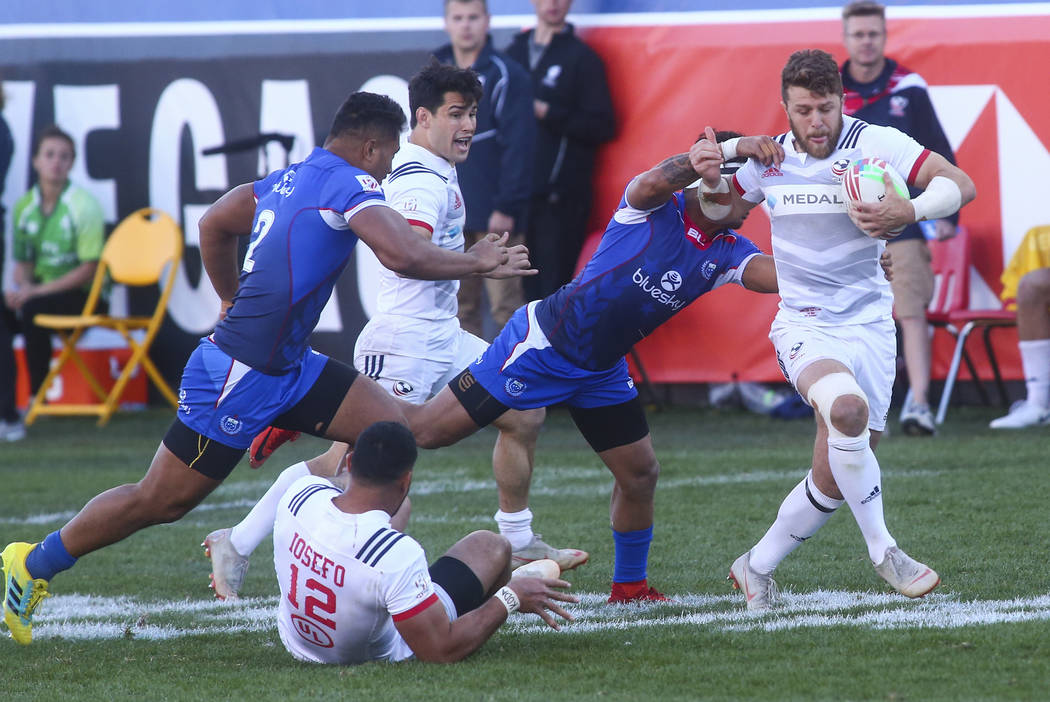 USA's Steve Tomasin, right, runs with the ball as Samoa's Melani Matavao tries to tackle him while competing in the Cup Final during the USA Sevens Rugby Tournament at Sam Boyd Stadium in Las Vega ...