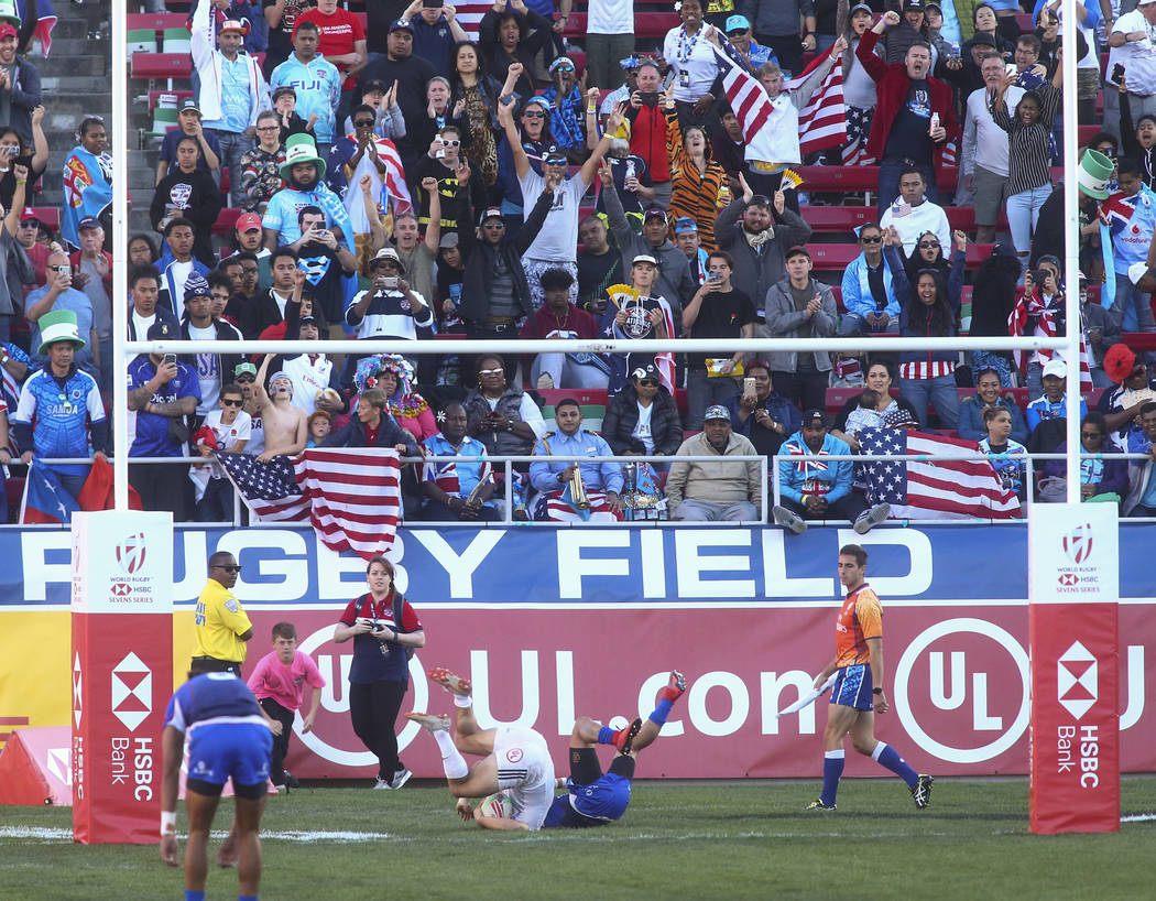USA's Madison Hughes, center left, scores a try against Samoa's Melani Matavao while competing in the Cup Final during the USA Sevens Rugby Tournament at Sam Boyd Stadium in Las Vegas on Sunday, M ...