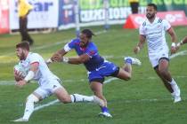 USA's Steve Tomasin, left, runs with the ball as Samoa's Siaosi Asofolau attempts to tackle while competing in the Cup Final during the USA Sevens Rugby Tournament at Sam Boyd Stadium in Las Vegas ...