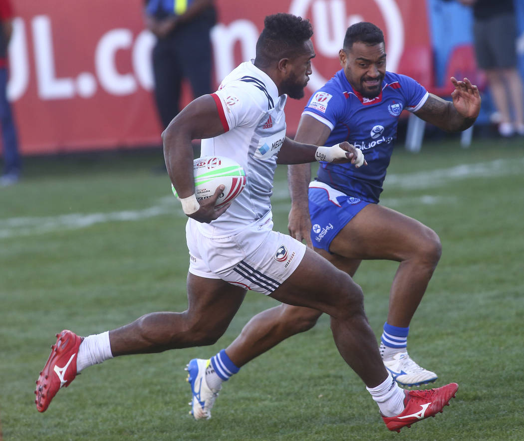 USA's Matai Leuta, left, runs with the ball against Samoa's Alamanda Motuga (2) on his way to score a try in the Cup Final during the USA Sevens Rugby Tournament at Sam Boyd Stadium in Las Vegas o ...