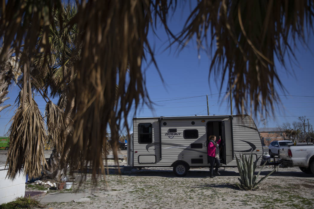 Paulina "Bela" Sebastiao steps out of the trailer she's been living in after her home was damaged from Hurricane Michael on the morning it is torn down in Mexico Beach, Fla, Friday, Jan. ...