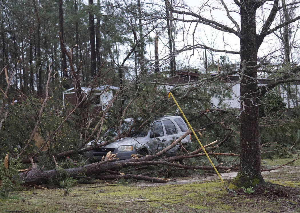 A vehicle is caught under downed trees along Lee Road 11 in Beauregard, Ala., Sunday, March 3, 2019, after a powerful storm system passed through the area. (Kara Coleman Fields/Opelika-Auburn News ...