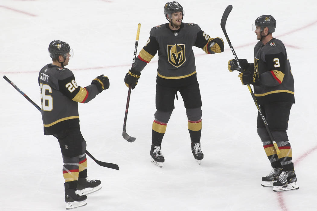Golden Knights defenseman Brayden McNabb (3) celebrates his goal with Golden Knights center Paul Stastny (26) and Golden Knights defenseman Shea Theodore during the third period of an NHL hockey g ...
