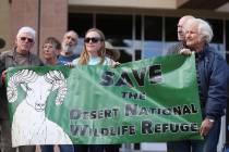 Grace Larsen, center, and Bob Furtek, right, members of Friends of Nevada Wilderness, hold up a sign during the Don't BombThe Bighorn Rally and Public Hearing at the Grant Sawyer State Office Buil ...