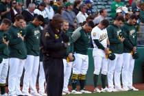 Oakland Athletics bow their heads in memory of Gretchen Piscotty, mother of right fielder Stephen Piscotty, prior to a baseball game against the Houston Astros Monday, May 7, 2018, in Oakland, Cal ...