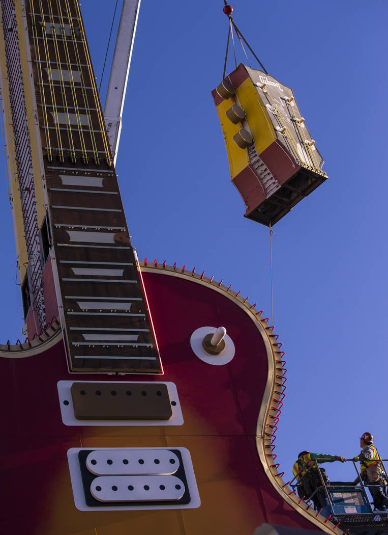 The headstock piece of the Hard Rock Cafe guitar sign is raised into the air as YESCO employees install the sign at the Neon Museum in Las Vegas on Friday, Feb. 1, 2019. (Chase Stevens/Las Vegas R ...