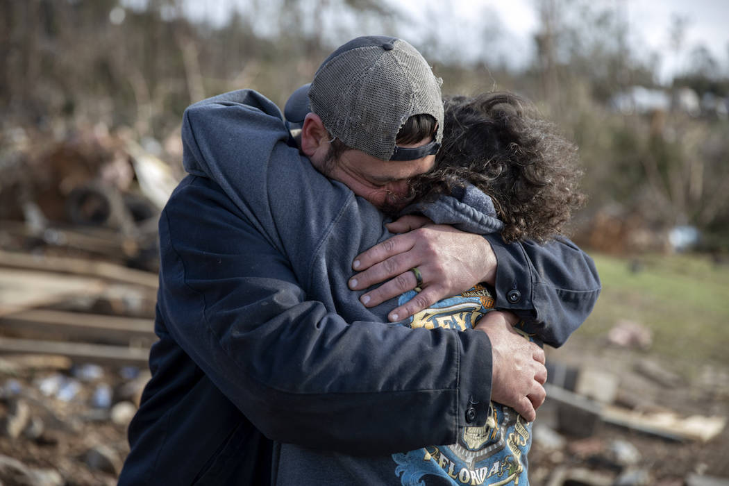 Carol Dean, right, is embraced by David Theo Dean as they sift through the debris of the home Carol shared her husband and David's father, David Wayne Dean, who died when a tornado destroyed the h ...