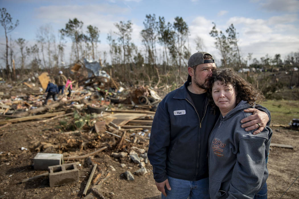 Carol Dean, right, is embraced by David Theo Dean as they sift through the debris of the home Carol shared her husband and David's father, David Wayne Dean, who died when a tornado destroyed the h ...