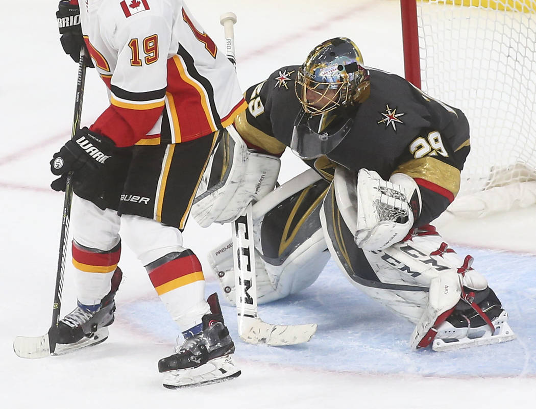 Golden Knights goaltender Marc-Andre Fleury (29) defends the net in front of Calgary Flames left wing Matthew Tkachuk (19) during the third period of an NHL hockey game at T-Mobile Arena in Las Ve ...