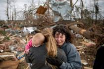 Carol Dean, right, cries while embraced by Megan Anderson and her 18-month-old daughter Madilyn, as Dean sifts through the debris of the home she shared with her husband, David Wayne Dean, who die ...