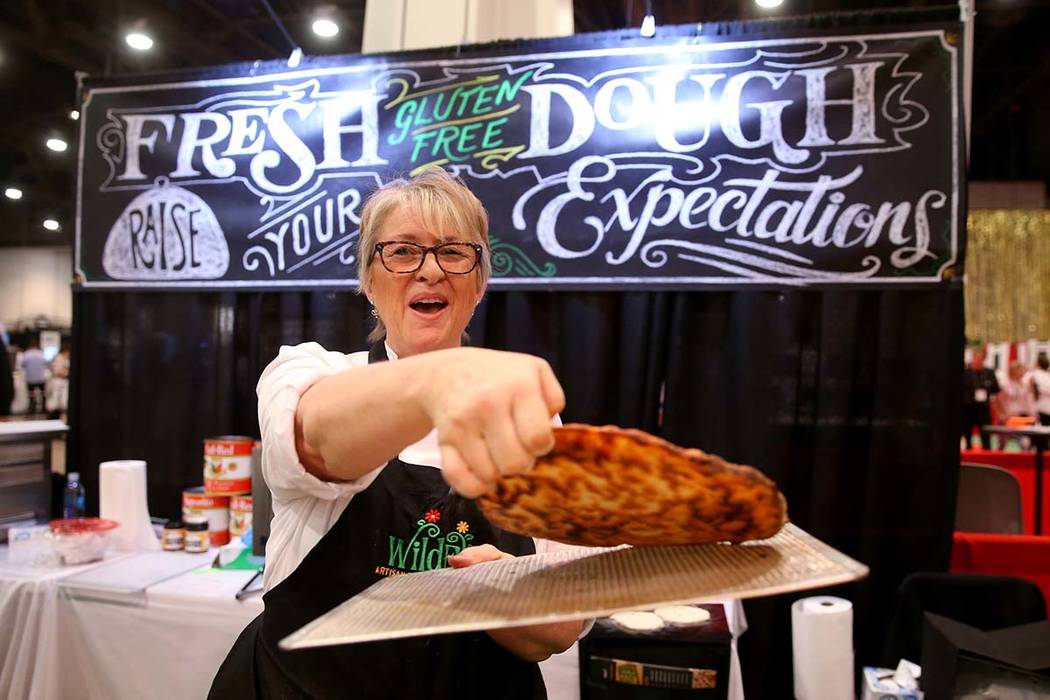 Kim Desch, of Wild Flour Bakery in Longmont, Colorado, shows the bottom of her gluten-free pizza at the International Pizza Expo at the Las Vegas Convention Center Tuesday, March 5, 2019. Desch sa ...