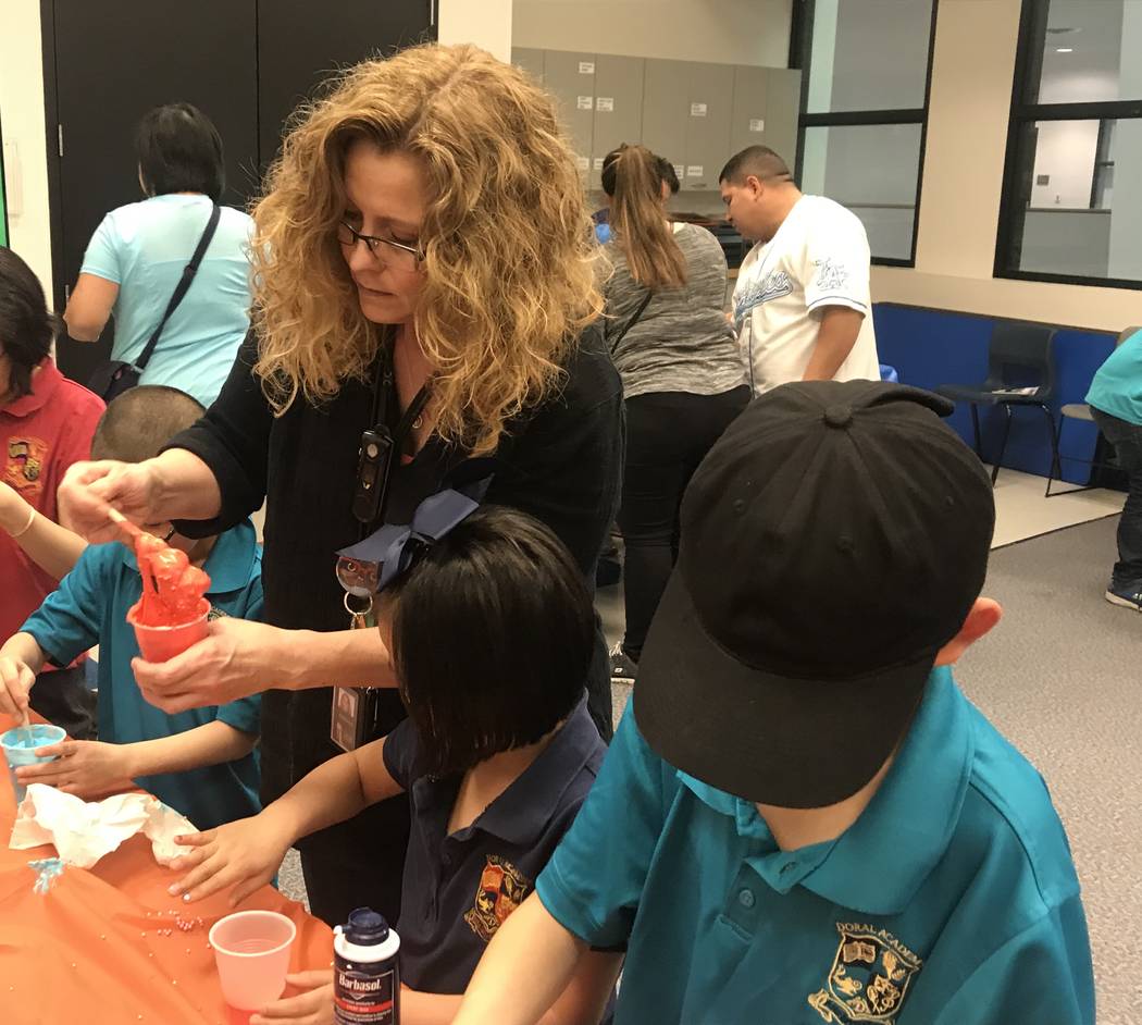 Kathryn Tilton, a youth services assistant at the Sahara West Library, helps children make slime after a presentation on on the world's most "gross" records. (Mia Sims-Las Vegas Review-Journal/@mi ...