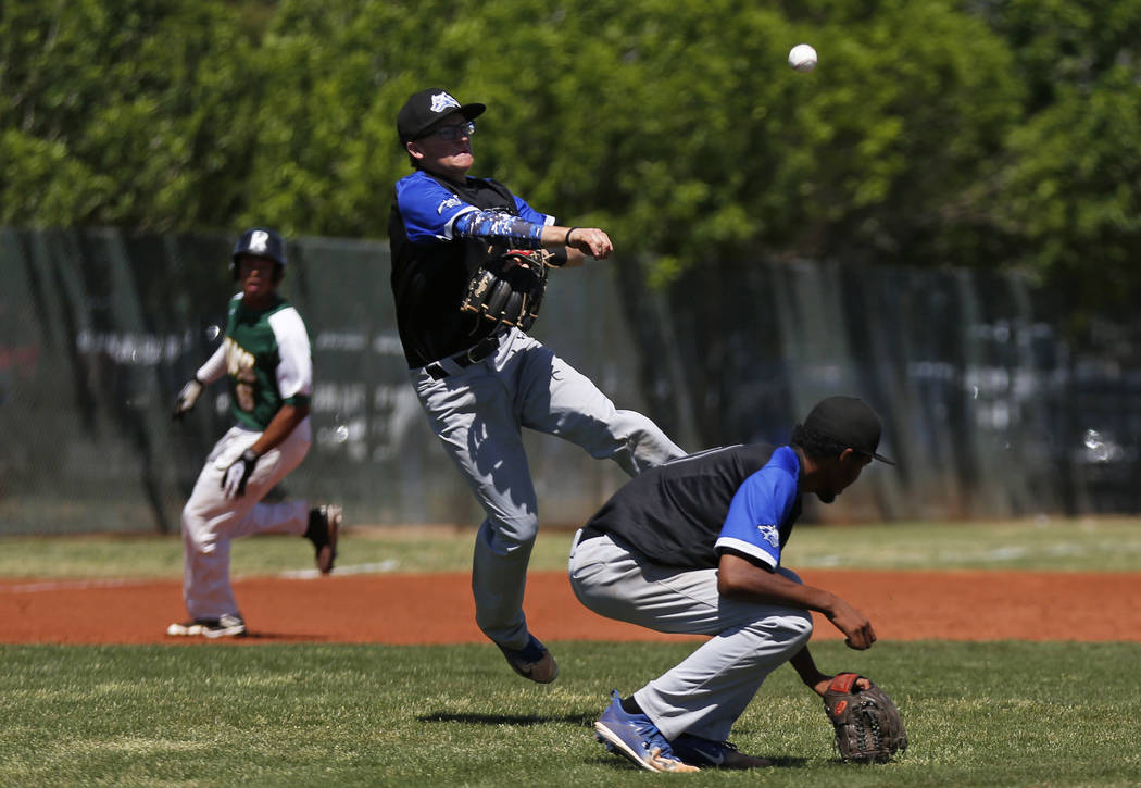 Basic's Garrett Giles (17) ducks while Kyle Turner (8) throws to first base against Rancho at Rancho High School in Las Vegas on Saturday, April 7, 2018. Rancho won 16-4. Andrea Cornejo Las Vegas ...