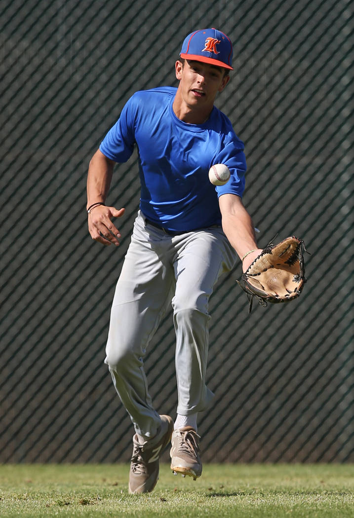 Bishop Gorman sophomore Carson Wells reaches for a ball during outfield drills at practice on Monday, April 16, 2018, at Bishop Gorman High School, in Las Vegas. The sophomore center fielder is al ...