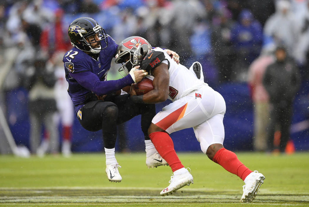 Tampa Bay Buccaneers running back Peyton Barber, right, rushes against Baltimore Ravens free safety Eric Weddle in the first half of an NFL football game, Sunday, Dec. 16, 2018, in Baltimore. (AP ...