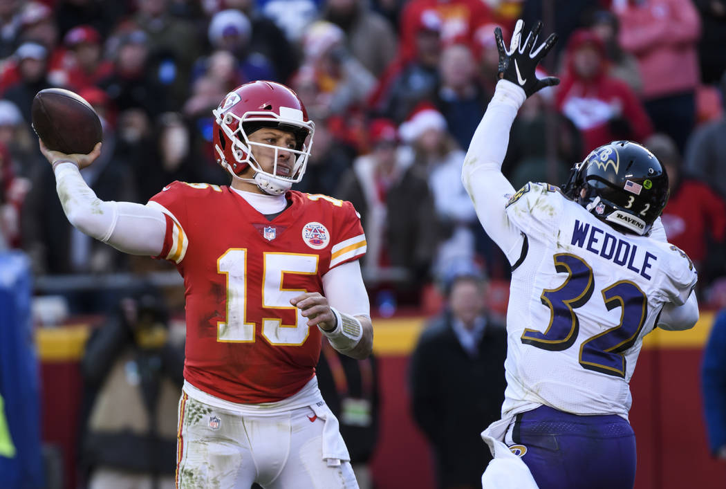 Kansas City Chiefs quarterback Patrick Mahomes (15) is pressured by Baltimore Ravens free safety Eric Weddle (32) during an NFL football game in Kansas City, Mo., Sunday, Dec. 9, 2018. (AP Photo/R ...