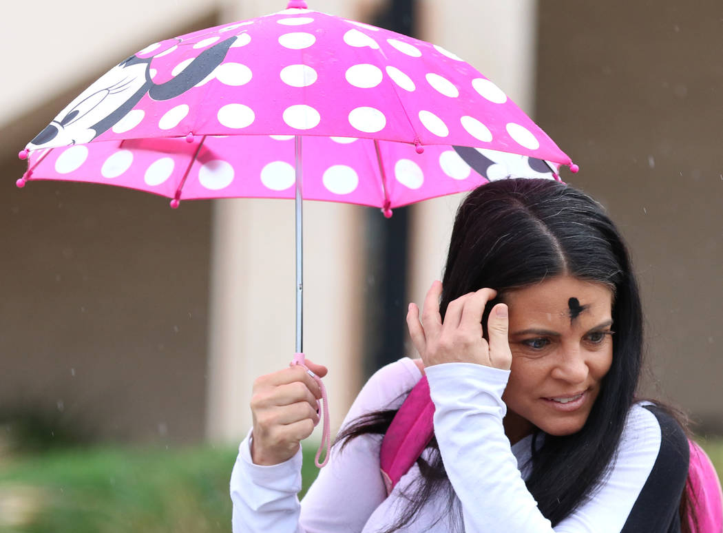 Lori Wood of Las Vegas holds an umbrella to protect herself from rain on Wednesday, March. 6, 2019, in Las Vegas. (Bizuayehu Tesfaye/Las Vegas Review-Journal) @bizutesfaye