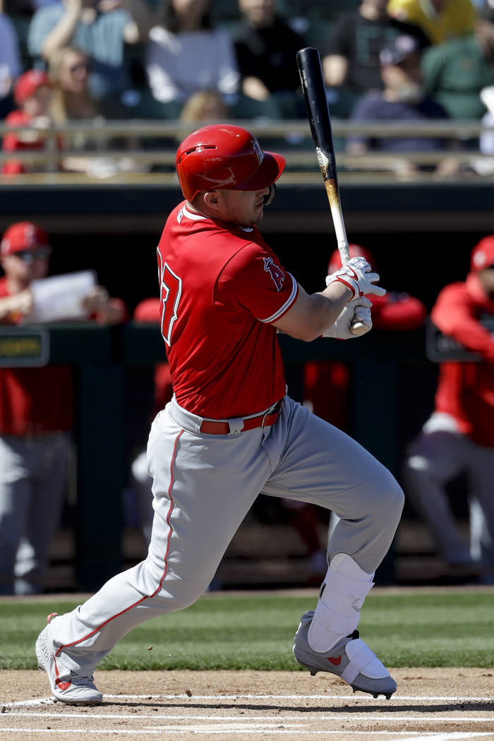 Los Angeles Angels center fielder Mike Trout hits a single against the Oakland Athletics during the first inning of a spring baseball game in Mesa, Ariz., Tuesday, Feb. 26, 2019. (AP Photo/Chris C ...