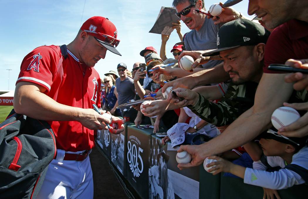 Los Angeles Angels' Mike Trout signs autographs prior to a spring training baseball game against the Kansas City Royals Friday, March 1, 2019, in Tempe, Ariz. (AP Photo/Ross D. Franklin)