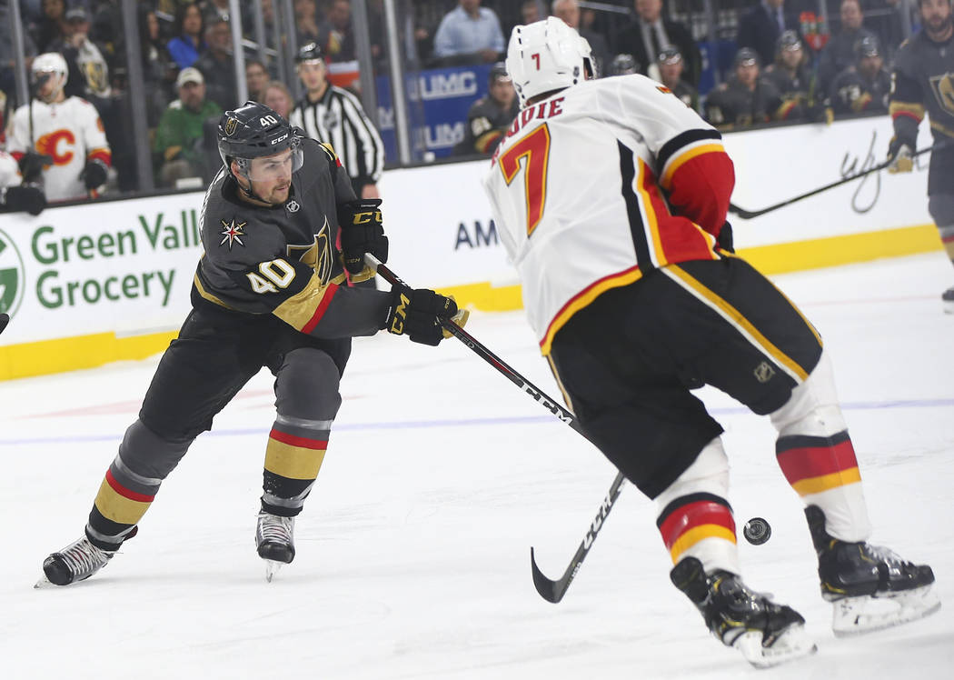 Golden Knights center Ryan Carpenter (40) sends the puck past Calgary Flames defenseman TJ Brodie (7) during the first period of an NHL hockey game at T-Mobile Arena in Las Vegas on Wednesday, Mar ...