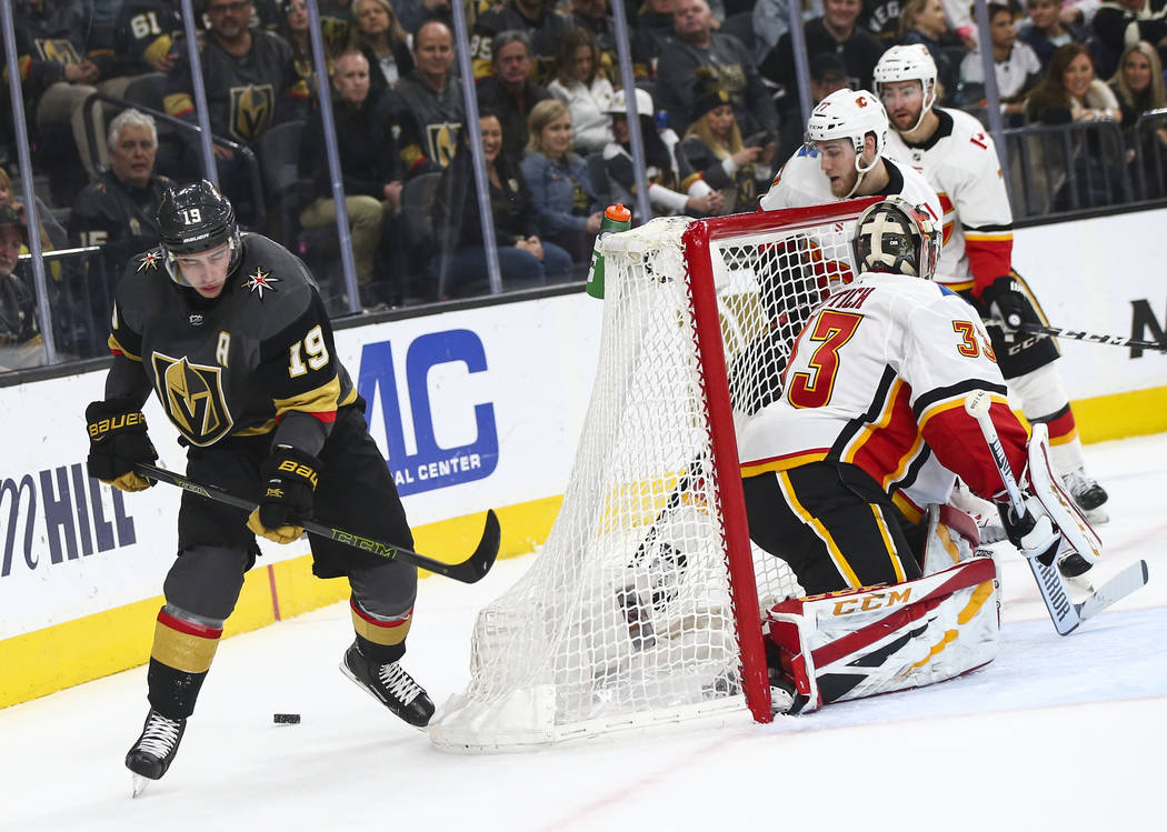 Golden Knights right wing Reilly Smith (19) skates around the net with the puck as Calgary Flames goaltender David Rittich (33) defends during the first period of an NHL hockey game at T-Mobile Ar ...