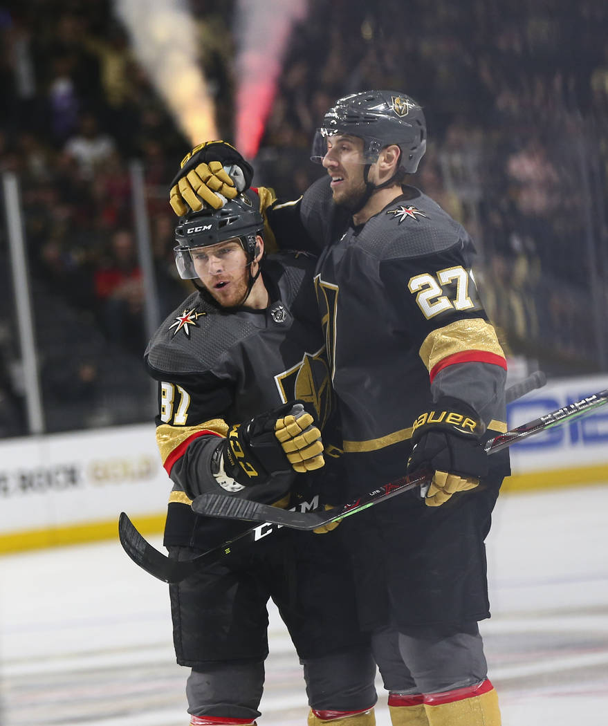 Golden Knights defenseman Shea Theodore (27) celebrates his goal with Golden Knights center Jonathan Marchessault (81) during the first period of an NHL hockey game against the Calgary Flames at T ...
