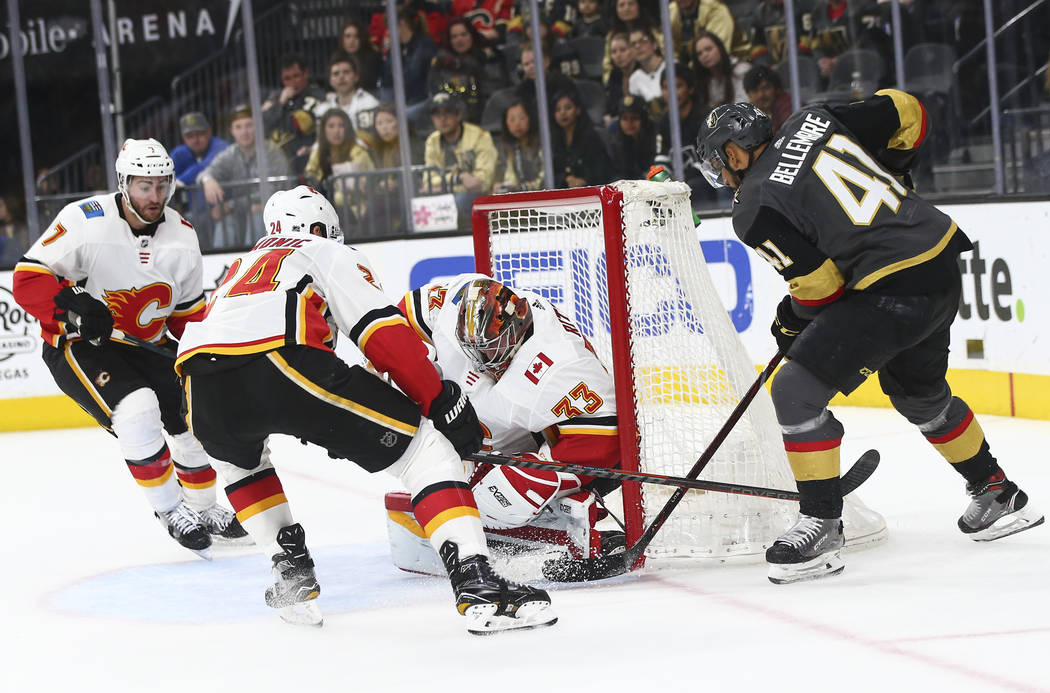 Golden Knights center Pierre-Edouard Bellemare (41) tries to get the puck in against Calgary Flames goaltender David Rittich (33) and Calgary Flames defenseman Travis Hamonic (24) during the secon ...