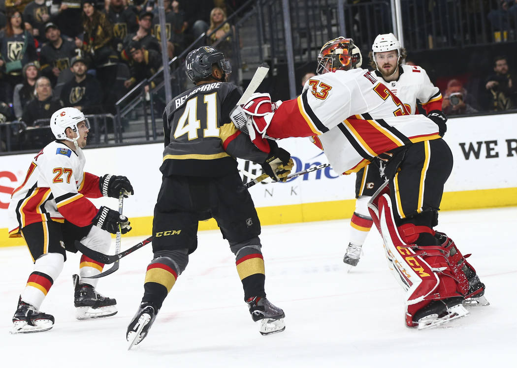 Calgary Flames goaltender David Rittich (33) pushes Golden Knights center Pierre-Edouard Bellemare (41) during the second period of an NHL hockey game at T-Mobile Arena in Las Vegas on Wednesday, ...