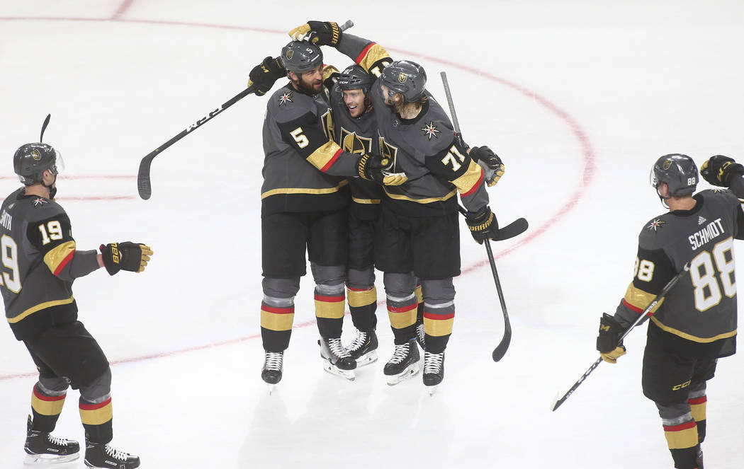 Golden Knights defenseman Deryk Engelland (5) celebrates his goal with Jonathan Marchessault, center, and William Karlsson (71) during the third period of an NHL hockey game against the Calgary Fl ...