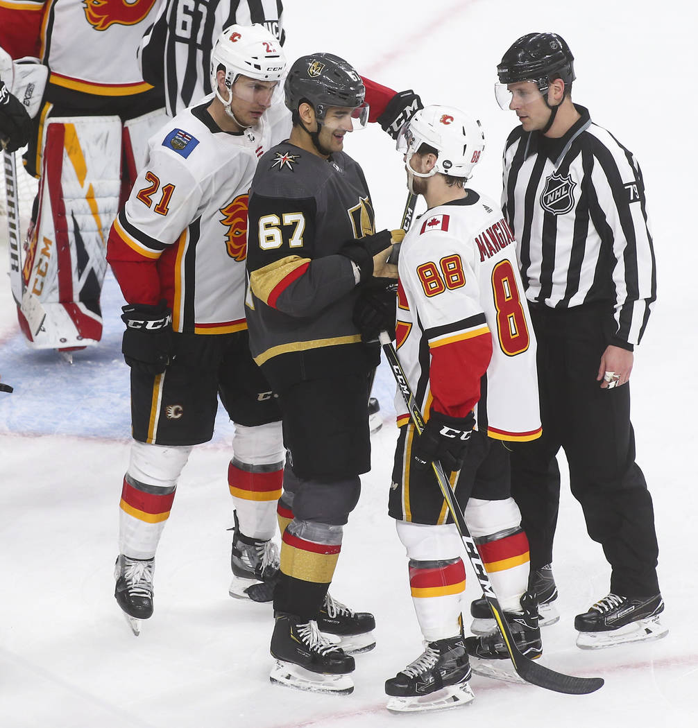 Golden Knights left wing Max Pacioretty (67) reacts while exchanging words with Calgary Flames left wing Andrew Mangiapane (88) while right wing Garnet Hathaway (21) looks on during the third peri ...