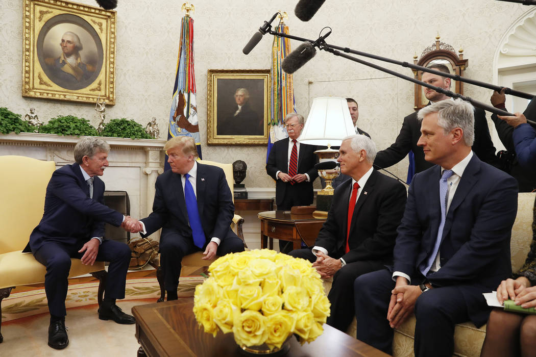 President Donald Trump shakes hands with former U.S. hostage in Yemen, Danny Burch, Wednesday, March 6, 2019, in the Oval Office of the White House in Washington, next to Vice President Mike Pence ...