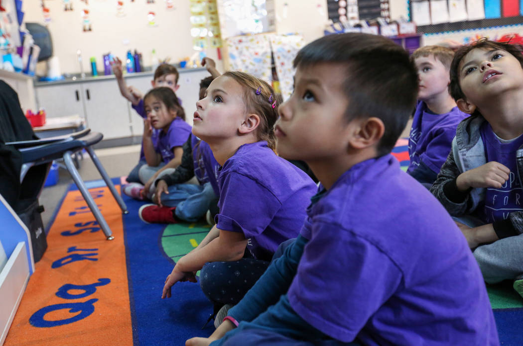 Kindergarten students watch images projecting on the screen as their teacher Nikki McGuire, background, asking them questions during a class at Staton Elementary in Las Vegas, Tuesday, March 5, 20 ...