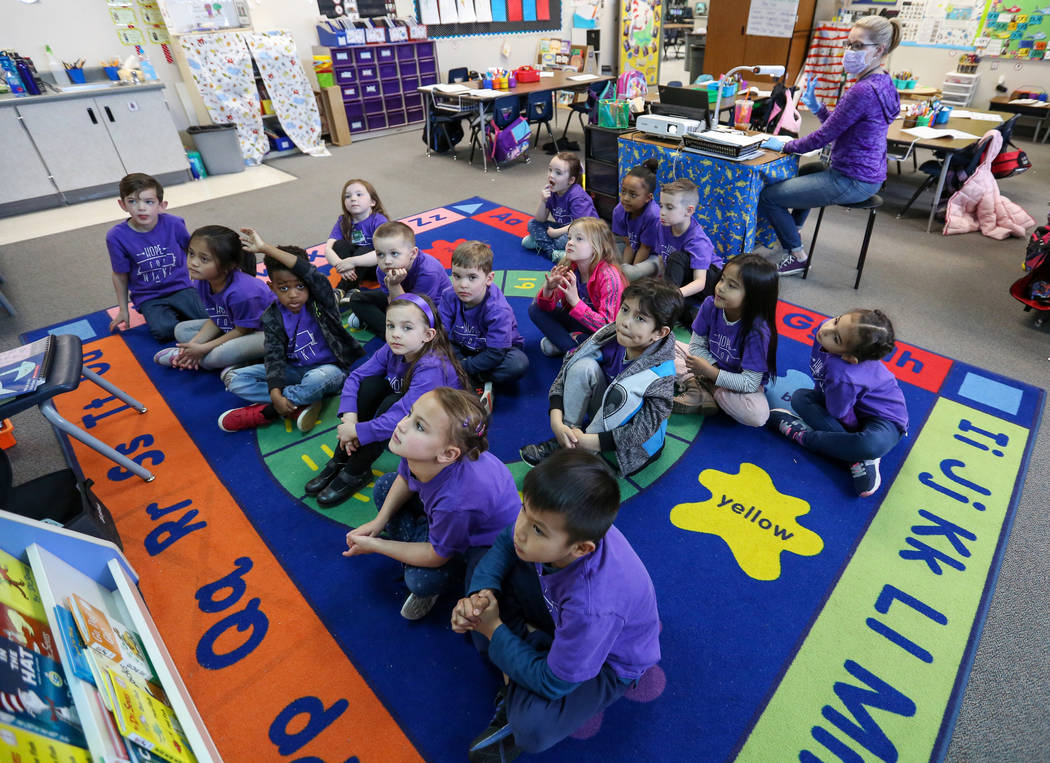 Kindergarten students watch images projecting on the screen as their teacher Nikki McGuire, background, asking them questions during a class at Staton Elementary in Las Vegas, Tuesday, March 5, 20 ...