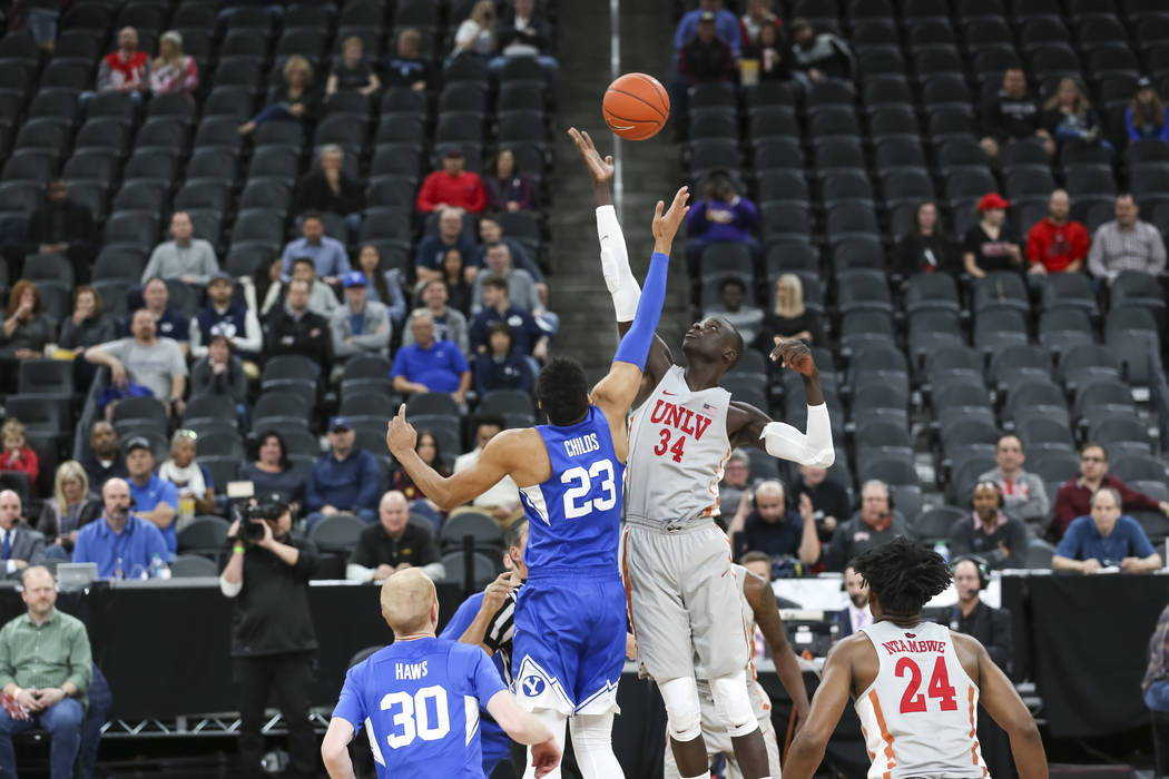 Brigham Young Cougars forward Yoeli Childs (23) and UNLV Rebels forward Cheikh Mbacke Diong (34) tip off to start the first half of an NCAA college basketball game at T-Mobile Arena in Las Vegas o ...