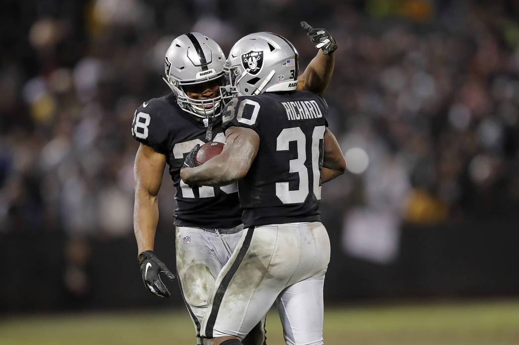 Oakland Raiders running back Jalen Richard (30) celebrates with running back Doug Martin (28) during the second half of an NFL football game against the Denver Broncos in Oakland, Calif., Monday, ...