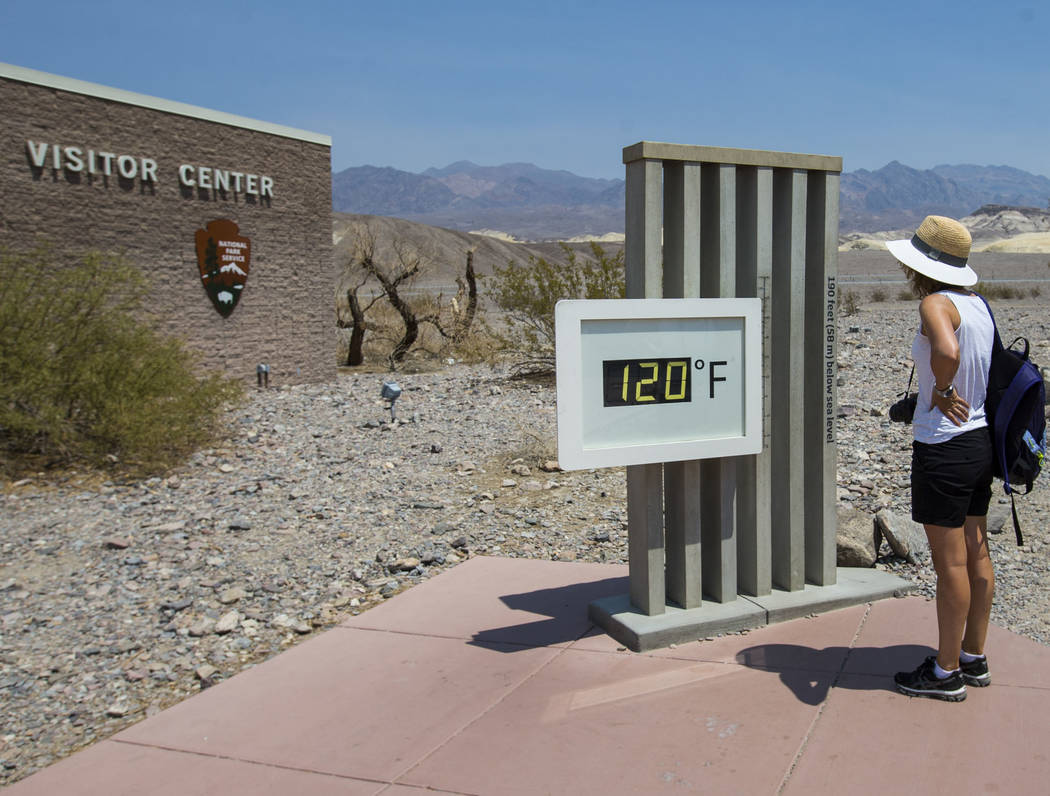 A visitor looks at the temperature displayed at visitor center at Death Valley National Park, Calif., on Tuesday, Aug. 7, 2018. (Chase Stevens Las Vegas Review-Journal @csstevensphoto)