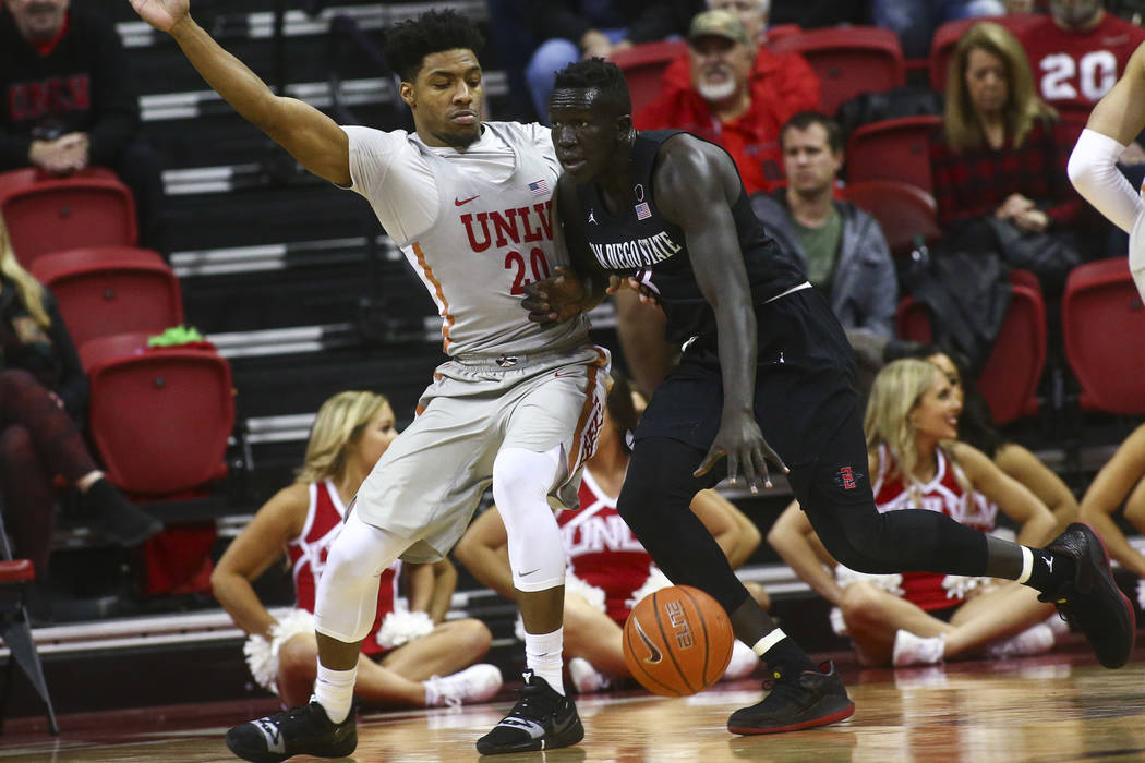 San Diego State Aztecs forward Aguek Arop (3) drives the ball against UNLV Rebels forward Nick Blair (20) during the second half of a basketball game at the Thomas & Mack Center in Las Vegas o ...