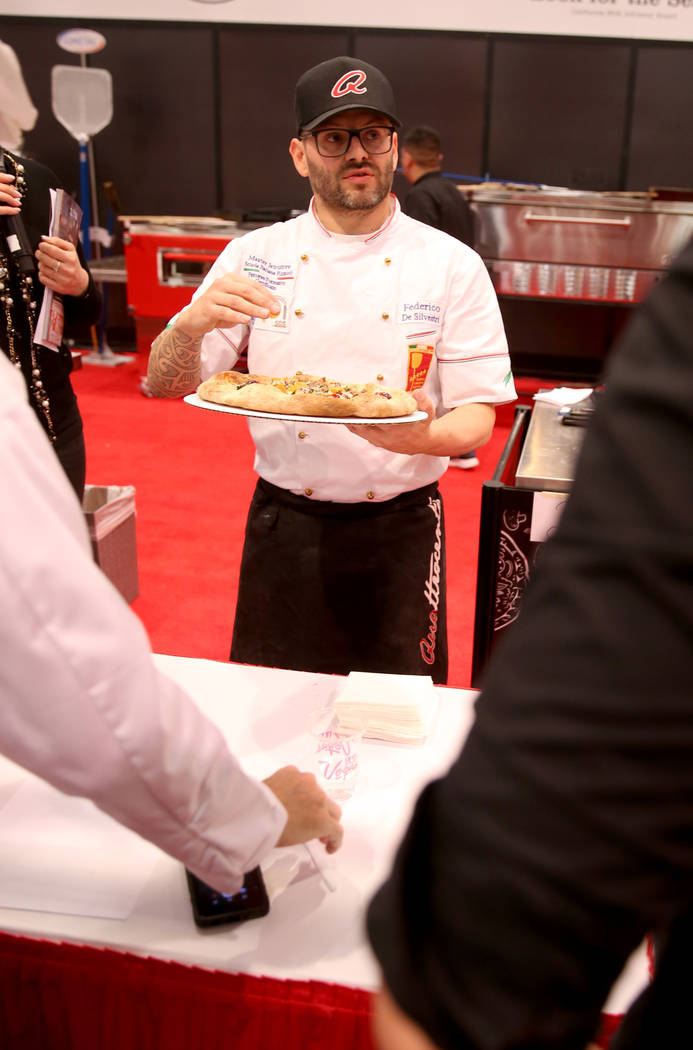Federico De Silvestri of Verona, Italy, presents his pizza to the judges while competing in the finals for the non-traditional pizza category during the International Pizza Challenge at the Intern ...