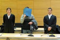 A 57-year old defendant hides his face at the courtroom in Bielefeld, Germany, Thursday, March 7, 2019. A judge in Germany has found the man guilty of poisoning his co-workers' sandwiches with mer ...