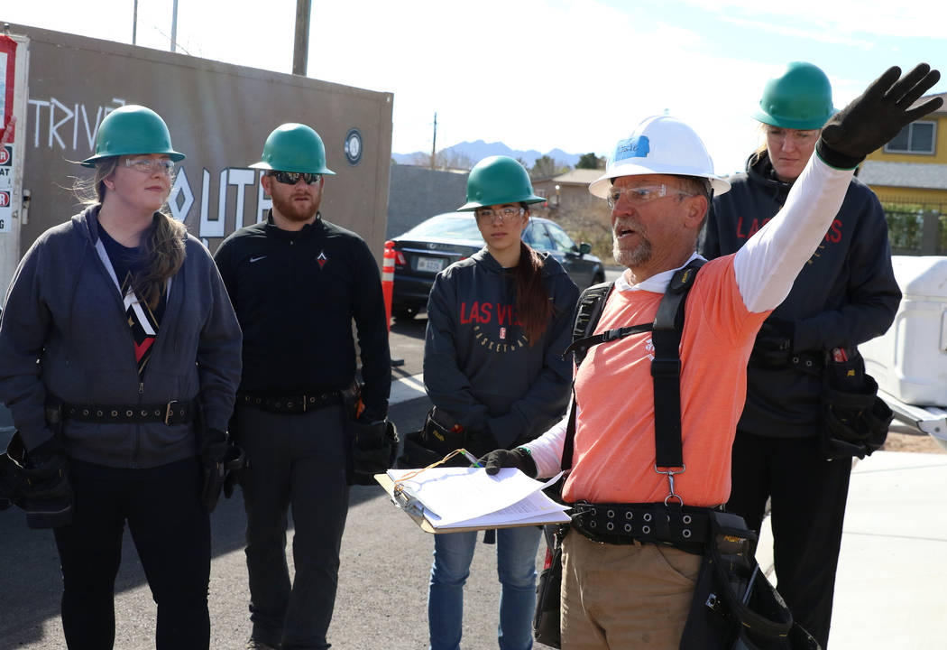 Las Vegas Aces center Carolyn Swords, right, and members of the Las Vegas Aces front office staff listen as John Maxwell, site supervisor for Habitat for Humanity, talks about construction safety ...