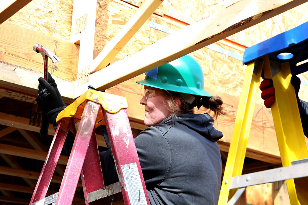 The Las Vegas Aces center Carolyn Swords hammers a nail as she volunteers with the construction of Habitat for Humanity Las Vegas' 112th home in celebration of International Women's Day on Friday, ...