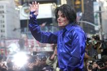 Michael Jackson waves to crowds gathered to see him at his first ever in-store appearance in New York on Nov. 7, 2001. (AP Photo/Suzanne Plunkett)