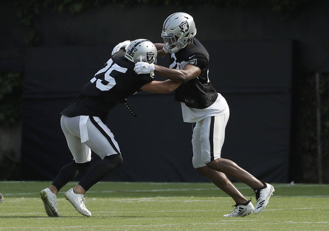 Oakland Raiders' Erik Harris, left, performs a drill with Obi Melifonwu during NFL football practice in Napa, Calif., Wednesday, Aug. 1, 2018. (AP Photo/Jeff Chiu)