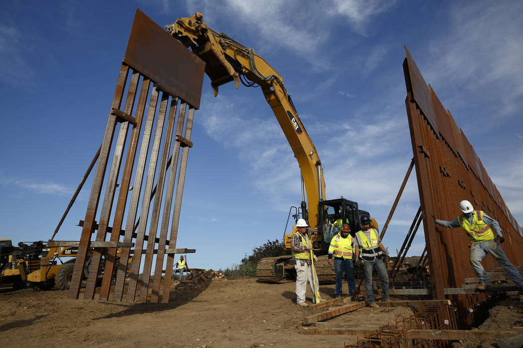 In this Jan. 9, 2019 file photo, construction crews install new border wall sections seen from Tijuana, Mexico. (AP Photo/Gregory Bull, File)