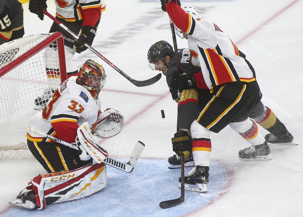 Golden Knights left wing Max Pacioretty tries to get the puck in between Calgary Flames goaltender David Rittich (33) and defenseman Rasmus Andersson during the third period of an NHL hockey game ...