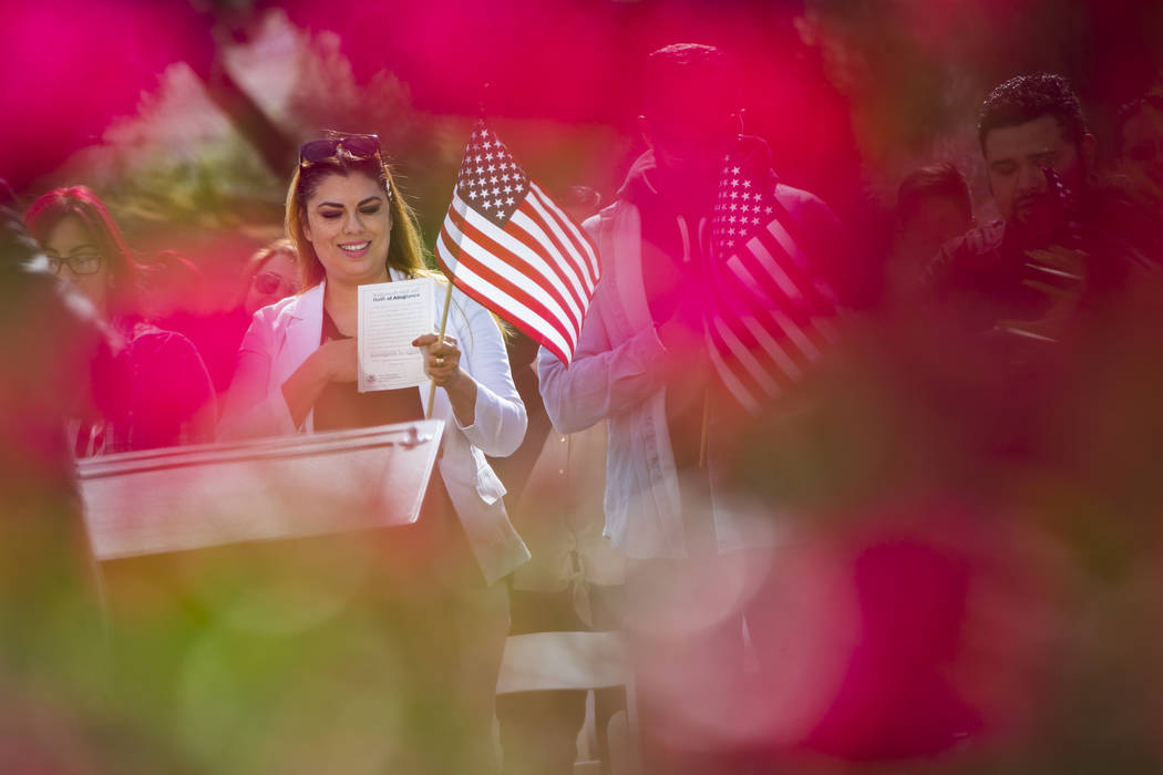 Irma Martinez of Tehachapi, Calif., who immigrated from Mexico, sings along to the national anthem during a naturalization ceremony at the Mission Gardens at The Inn at Death Valley in Death Valle ...
