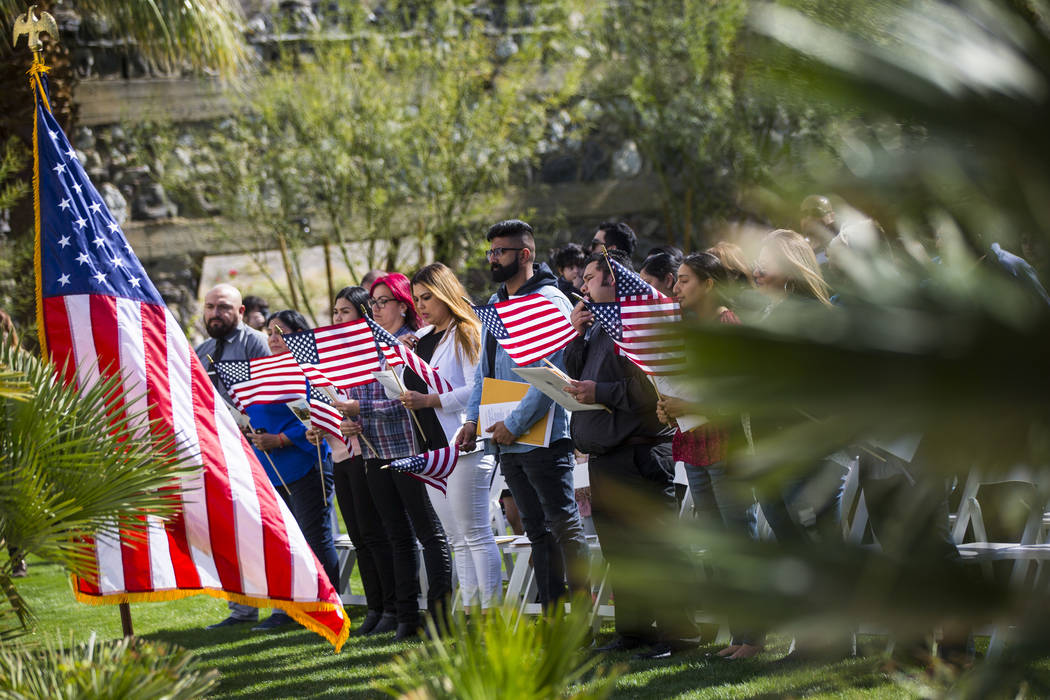People sing along to the national anthem during a naturalization ceremony at the Mission Gardens at The Inn at Death Valley in Death Valley National Park, Calif., on Friday, March 8, 2019. (Chase ...